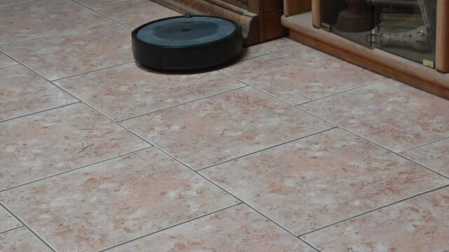EL PASO, UNITED STATES - Jul 02, 2021: The robot Roomba cleaning and vacuuming a tile floor