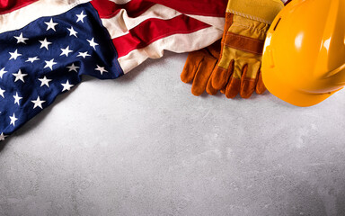 Happy Labor day concept. American flag with different construction tools on dark stone background.