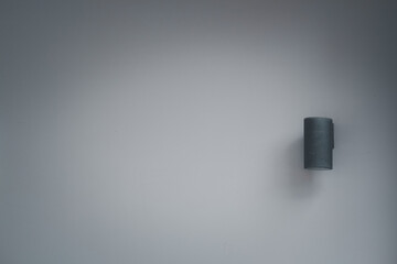 Cylinder black wall lamp on wall with copy space