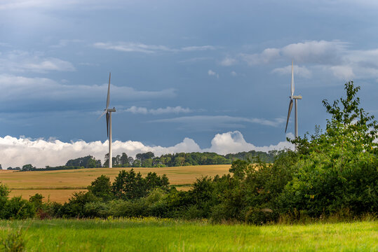 Winmill in the farmland, green fields, dark sky
