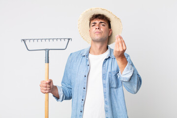 young handsome man making capice or money gesture, telling you to pay. farmer concept