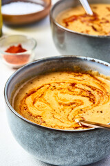 Lentil turkish yellow-coloured cream soup in a grey bowl. The second bowl is on the background. 45 angle view