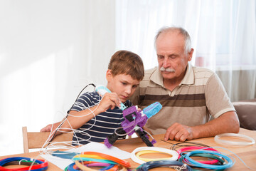 Kid boy and his drandfather using 3d printing drawing pen. Creative, leisure engineering. Technology. Robotics. 