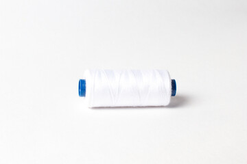A spool of white thread. White background.