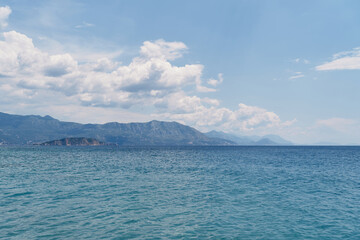 View from the sea to the mountains and the island against the background of blue sky