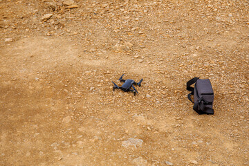 An unmanned aerial vehicle with a radio-controlled camera on the sand before taking to the sky. New technologies for video and photo shooting.
