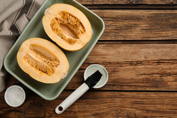 Halves of fresh spaghetti squash in baking dish on wooden table, flat lay with space for text. Cooking at home