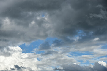 Gray and white rolling puffy clouds floating in the sky. Concept Storm Clouds Raining.
