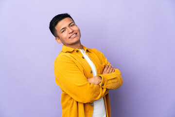 Young Ecuadorian man isolated on purple background with arms crossed and looking forward