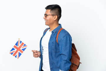 Young Ecuadorian woman holding an United Kingdom flag isolated on white background laughing in lateral position