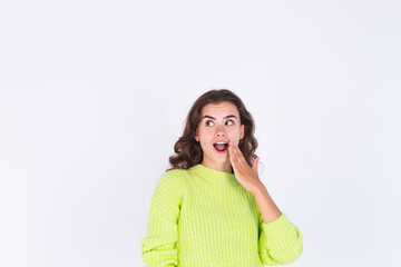 Young beautiful woman with freckles light makeup in sweater on white background gossip talk listen secret