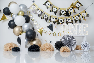 Celebrating 1 year old. Gold theme, black and white. with balloons and lights