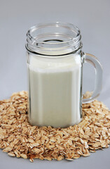 white milk kefir in a glass mug and dry dietary oat flakes
