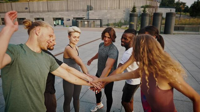 Group hand shake. Young beautiful group of sportswomen standing shaking hands after after a successful workout