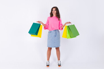 Young beautiful woman with freckles light makeup in pink sweater and jeans skirt on white background stylish full length hold shopping bags