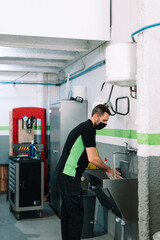  workman washing hands under tap with water after finishing work in repair service workshop