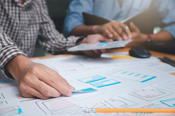 UX or UI designers designing on their smartphone application layout prototype project.