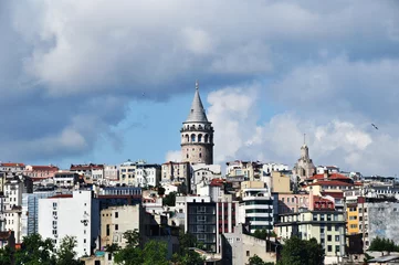 Deurstickers A close-up of the Galata Tower against the backdrop of residential buildings. Cityscape of Istanbul. 07 July 2021, Istanbul, Turkey. © Viacheslav