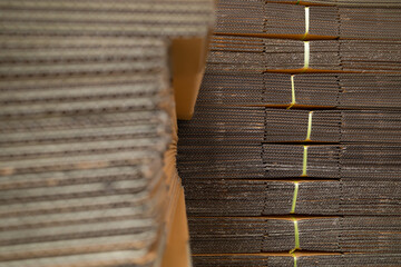 Stack of corrugated cardboard boxes tied with nylon rope and stacked in layers.