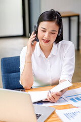 Fototapeta premium Portrait of happy smiling female customer support phone operator at workplace,call-center agent or customer service position talking on the phone.