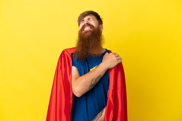 Redhead Super Hero man isolated on yellow background suffering from pain in shoulder for having made an effort © luismolinero