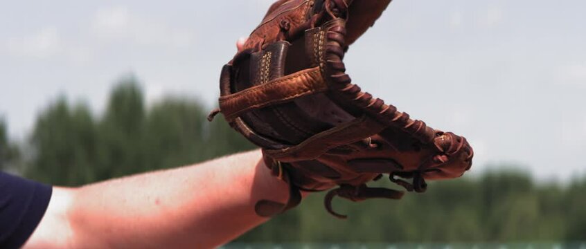Super slow motion shot of Caucasian teenager baseball player catching a ball outside. Shot with high speed video camera at 420 FPS