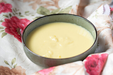 creamy sweetcorn soup in a cup on a floral background