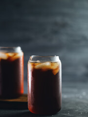 Iced coffee in a tall glass on a black table. Cold summer drink