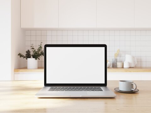 Laptop computer with blank white display available for adding your content. Kitchen in background. 3D illustration.