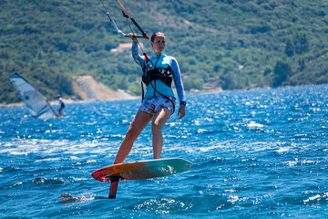 CLOSE UP: Fit female tourist surfs on a foil board along the Peljesac peninsula.