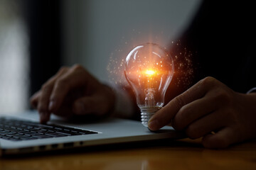 Business man Hand of male holding a light bulb for accounting and creative concept.