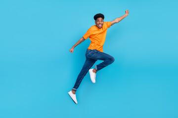 Full body photo of young dark skin happy man jump up superhero good mood isolated on blue color background