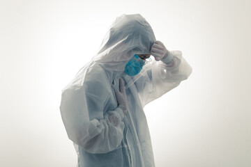 Crying volunteer during COVID-19 in serious pandemic crisis. Healthcare workers in hazmat suit PPE...