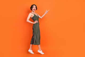 Full body profile side photo of young girl amazed happy smile point finger empty space ad choose...