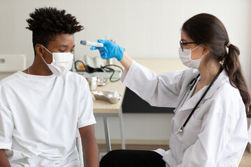 woman doctor scanning fever temperature with digital thermometer to patient before getting vaccine