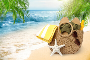 Stylish bag with different accessories on tropical sandy beach, space for text
