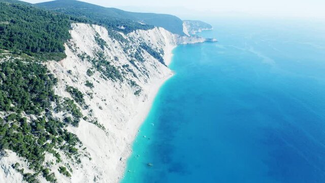 Drone raising shot of beautiful scenic beach with white sand and turquoise blue sea water, summer holiday in Greece, Egremni beach of Lefkada island.