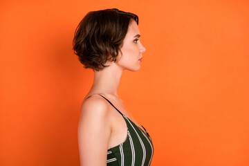 Obraz premium Profile side photo of young girl serious calm confident focused look empty space isolated over orange color background