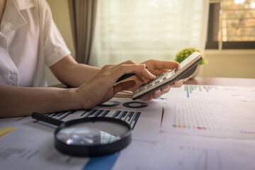 Auditors are using calculators to check financial audits, company earnings data, income and loss...