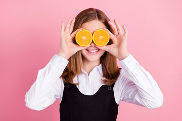 Photo of childish funny school girl wear white black uniform smiling holding two citrus slices...