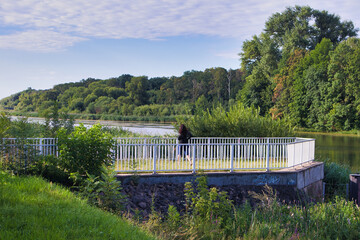 Aussichtsplattform mit wei&szlig;em Gel&auml;nder an einem Wehr der Neuen Luppe vor einem bewaldeten Flussufer, Leipzig, Sachsen, Deutschland