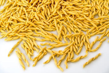 Italian traditional homemade pasta. Strozzapreti macaroni on white background. Top view