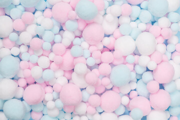 White, pink and blue soft pompons as a background.