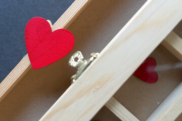 Fototapeta na wymiar wooden hearts hand painted red and plain wooden jewelry box - photographed from above in a flat lay style in ambient light