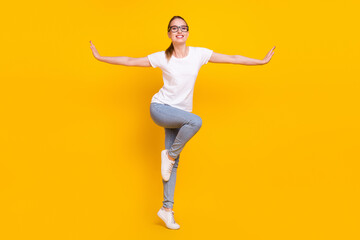 Fototapeta na wymiar Full length photo of happy positive young charming woman hold hands wings smile isolated on yellow color background
