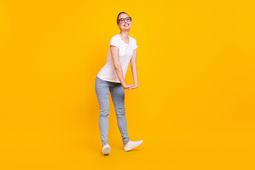 Full body profile side photo of young cheerful girl happy positive smile have fun plaful isolated over yellow color background