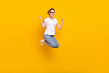 Fototapeta na wymiar Full body photo of young happy woman jump up raise fists winner celebrate isolated on yellow color background