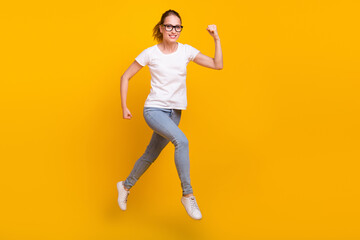 Fototapeta na wymiar Full length photo of cheerful woman jump up run empty space sale dream travel isolated on yellow color background