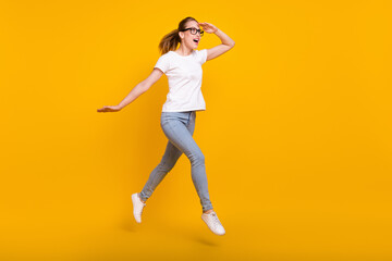 Fototapeta na wymiar Full length photo of happy amazed brown haired woman jump wear casual clothes look empty space jump run isolated on yellow color background