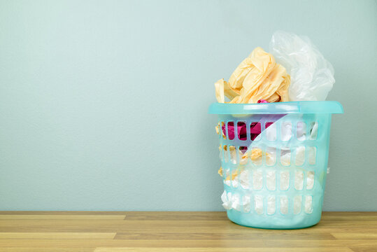 Many plastic bags are kept in the plastic basket bin to reuse on the floor